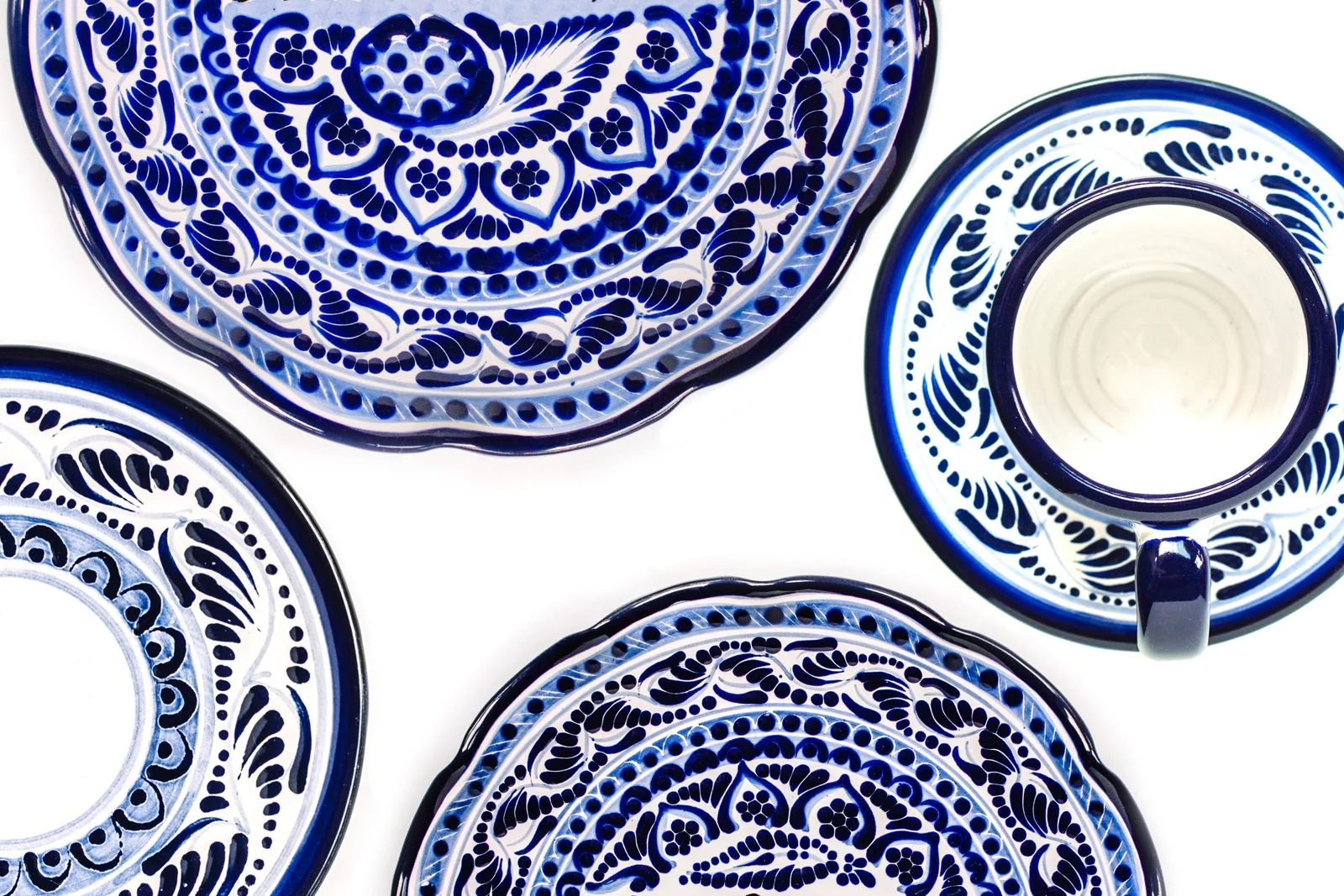 Handmade blue-and-white Mexican Talavera plates and a cup with floral patterns
